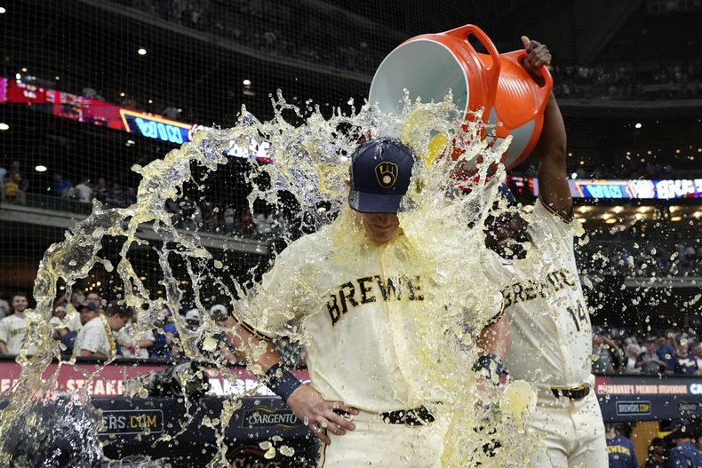 Andrew Vaughn de los Cerveceros de Milwaukeees bañado por el venezolano Andruw Monasterio tras la victoria ante los Cachorros de Chicago el martes 29 de julio del 2025. (AP Foto/Aaron Gash)