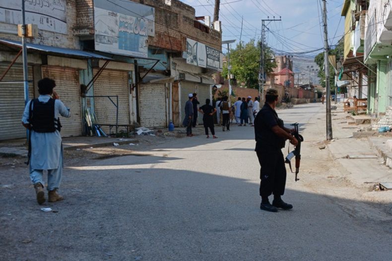 En esta imagen, tomada con un smartphone, agentes de policía custodian una carretera cerca de donde se produjo una potente explosión en una mezquita en Kohat, Pakistán, el 18 de septiembre de 2026. (AP Foto/B.S. Gillani)