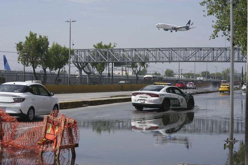 Los conductores cruzan una calle inundada afuera del Aeropuerto Internacional Benito Juárez en la Ciudad de México, el martes 12 de agosto de 2025. (AP Foto/Fernando Llano)