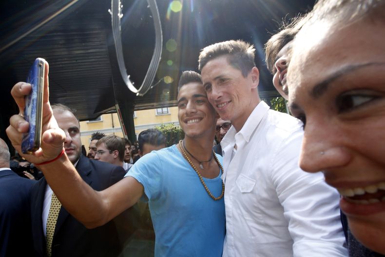El jugador del Milan, Fernando Torres, centro, posa junto con un fan&aacute;tico que se toma un selfie el s&aacute;bado, 30 de agosto de 2014, tras llegar al reconocimiento m&eacute;dico con su nuevo club en Mil&aacute;n, Italia. (AP Photo/Luca Bruno)