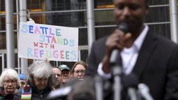 Una persona muestra un cartel de apoyo a los refugiados durante la intervención de Tshishiku Henry, un antiguo refugiado y delegado de Refugee Congress para el estado de Washington, en un mitin en el exterior de la Corte de Distrito de Estados Unidos luego de que un juez federal bloqueó una iniciativa de Donald Trump para suspender el programa de admisiones de refugiados del país, el 25 de febrero de 2025 en Seattle. (AP Foto/Ryan Sun)