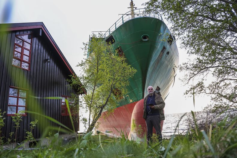 Johan Helberg se ve junto a su casa, con el buque portacontenedores NCL Salten al fondo, después de que el carguero de 135 metros se quedara encallado en Trondheimsfjord, a las afueras de Byneset, en Trondheim, Noruega el jueves 22 de mayo de 2025. (Jan Langhaug/NTB Scanpix via AP)