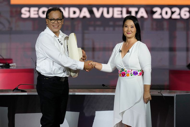 Los aspirantes a la presidencia de Perú Keiko Fujimori, de Fuerza Popular, y Roberto Sánchez, de Juntos por Perú, se dan la mano antes de un debate presidencial en Lima, Perú, el domingo 31 de mayo de 2026. (AP Foto/Martin Mejia)