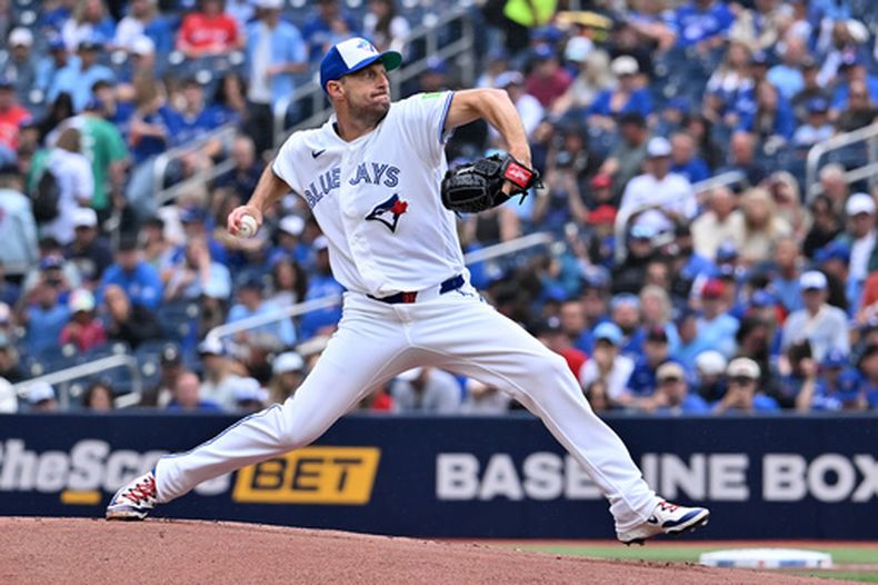 Max Scherzer, pitcher de los Azulejos de Toronto, lanza a un bateador de los Marineros de Seattle durante la primera entrada del juego de béisbol en Toronto del domingo 30 de agosto de 2026. (Jon Blacker/The Canadian Press via AP)