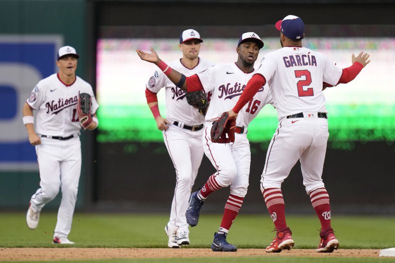 Víctor Robles (16) y Luis García (2), de los Nacionales de Washington festejan después del juego de béisbol en contra de los Piratas de Pittsburgh, el domingo 30 de abril de 2023, en Washington. Los Nacionales ganaron 7-2. También en la foto, los jardineros Alex Call, izquierda, y Lane Thomas. (AP Foto/Patrick Semansky)