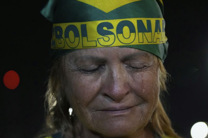 Una partidaria del expresidente brasileño Jair Bolsonaro llora durante una vigilia en su apoyo cerca de su casa, donde se encuentra bajo arresto domiciliario en Brasilia, Brasil, el jueves 11 de septiembre de 2025. (AP Foto/Eraldo Peres)