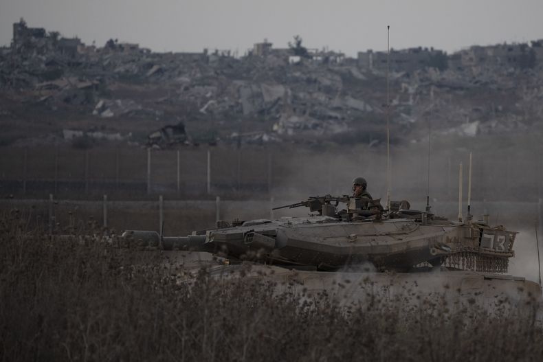 Soldados israelíes a bordo de un tanque cerca de la frontera entre Israel y Gaza, en una imagen tomada desde el sur de Israel, el miércoles 21 de agosto de 2024. (AP Foto/Leo Correa)