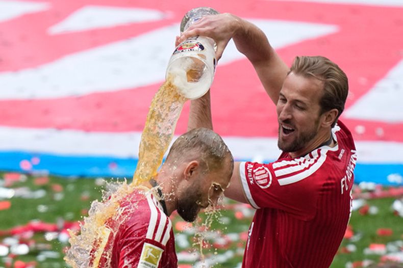 Harry Kane, del Bayern, le vierte cerveza a su compañero Joshua Kimmich mientras celebran el título de la Bundesliga al final del partido de fútbol entre el Bayern y el FC Colonia en Múnich, Alemania, el sábado 16 de mayo de 2026. (Foto AP/Matthias Schrader)