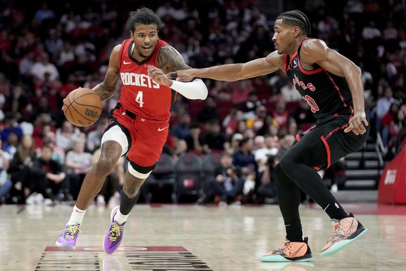 El escolta de los Rockets de Houston, Jalen Green (4), regatea mientras el escolta de los Raptors de Toronto, Ochai Agbaji, a la derecha, defiende durante la primera mitad de un partido de baloncesto de la NBA, el domingo 9 de febrero de 2025, en Houston. (AP Foto/Eric Christian Smith)