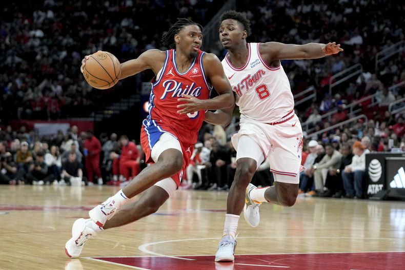 El armador de los 76ers de Filadelfia Tyrese Maxey (izquierda) conduce para rebasar al alero JaeSean Tate durante la 1ra mitad del juego de baloncesto de la NBA el viernes 29 de diciembre de 2023, en Houston. (AP Foto/Eric Christian Smith)