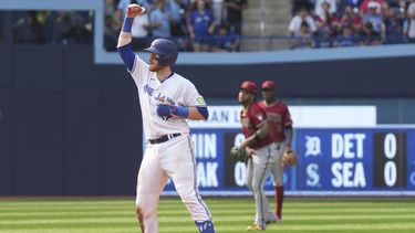 Danny Jansen de los Azulejos de Toronto celebra sobre la segunda base luego de conectar un doblete de tres carreras ante Scott McCough de los Diamondbacks de Arizona, durante el octavo episodio del juego en Toronto. Domingo 16 de julio de 2023. (Chris Young/The Canadian Press via AP)
