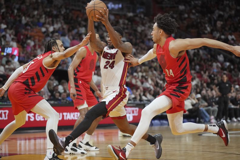 Haywood Highsmith (24), del Heat de Miami, ataca la canasta entre dos jugadores de los Trail Blazers de Portland durante la segunda mitad del juego de baloncesto de la NBA, el viernes 29 de marzo de 2024, en Miami. (AP Foto/Jim Rassol)