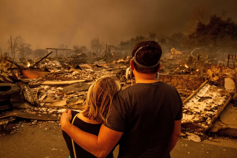 ARCHIVO - Megan Mantia, a la izquierda, y su novio Thomas, regresan a la casa de Mantia, dañada por el fuego luego que el incendio Eaton arrasara Altadena, California, el miércoles 8 de enero de 2025. (AP Foto/Ethan Swope, archivo)