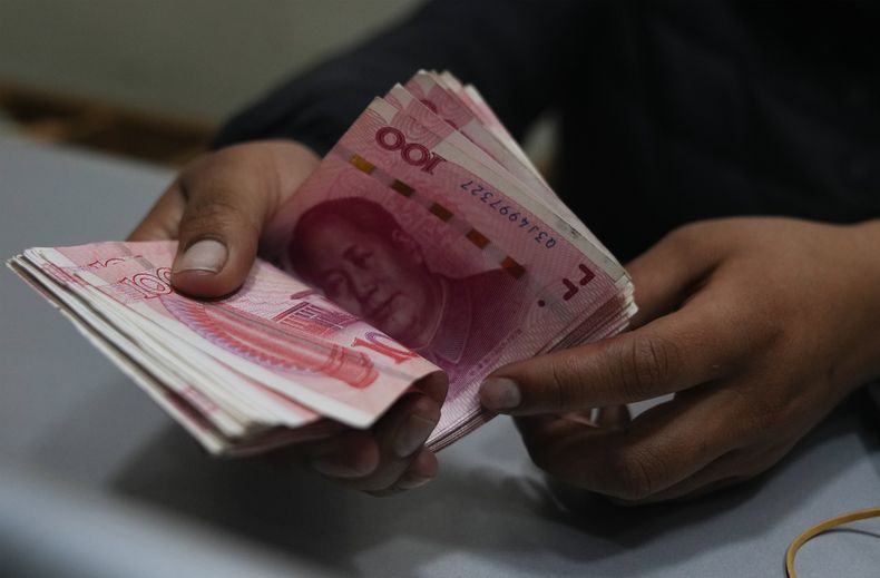 Un trabajador de una casa de cambio cuenta billetes de yuanes chinos en La Paz, Bolivia, el miércoles 26 de julio de 2023. El banco estatal boliviano, Banco Unión, comenzó a ejecutar transacciones de comercio internacional usando la moneda china: el yuan. (AP Foto/Juan Karita)