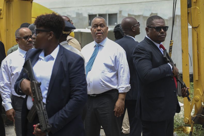 Agentes de seguridad armados escoltan al primer ministro haitiano Garry Conille mientras visita el Hospital General en Puerto Príncipe, Haití, martes 9 de julio de 2024. (AP Foto/Odelyn Joseph)
