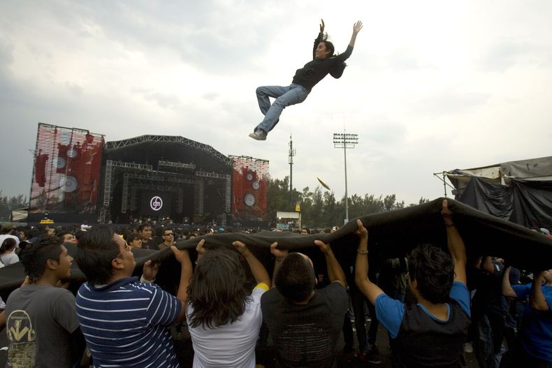 ARCHIVO - Una fan del rock and roll es lanzada al aire durante el festival Vive Latino en el Foro Sol, en la Ciudad de México, el 5 de mayo de 2007. (Foto AP/Eduardo Verdugo, archivo)