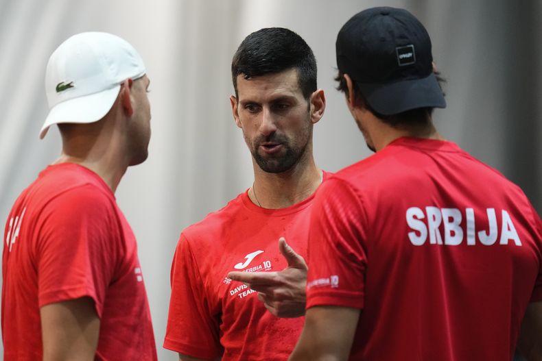 Novak Djokovic, centro, de Serbia, platica con sus compañeros de equipo durante una sesión de entrenamiento de la Copa Davis, en Málaga, España, el martes 21 de noviembre de 2023. (AP Foto/Manu Fernández)
