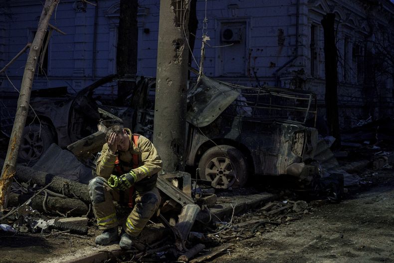 Un rescatista descansa cerca de un edificio universitario destruido por un ataque de misil en Sumy, Ucrania, el domingo 13 de abril de 2025. (AP Foto/Evgeniy Maloletka)