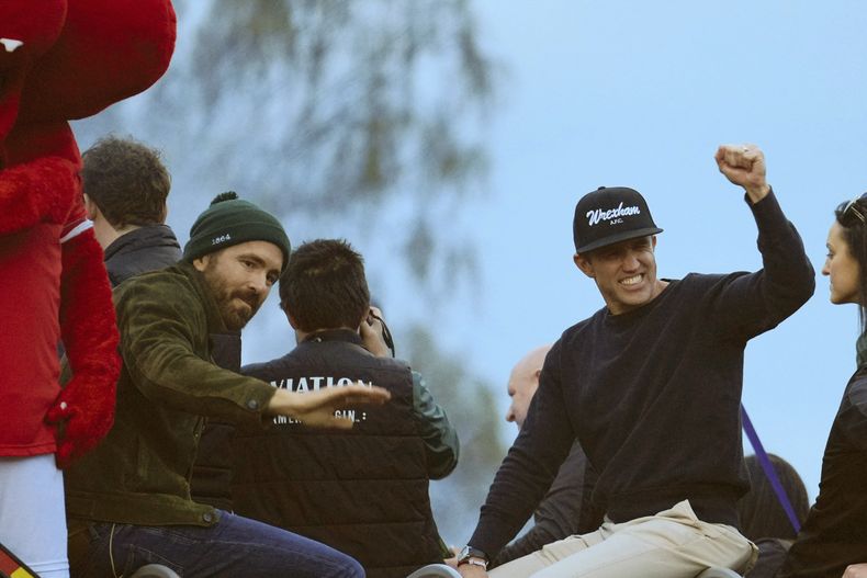 ARCHIVO - Los copropietarios de Wrexham, Ryan Reynolds, izquierda, y Rob McElhenney, derecha, celebran el ascenso de su equipo a la Football League en Wrexham, Gales, el martes 2 de mayo de 2023. (Foto AP/Jon Super, archivo)