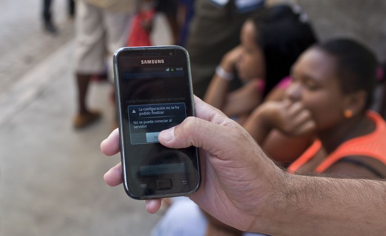 Un hombre muestra el aviso de que su tel&eacute;fono celular no puede conectarse con el servidor en  La Habana el 9 de mayo del 2014. El reciente lanzamiento de un servicio de telefon&iacute;a m&oacute;vil en Cuba fue un fiasco ya que la red no pudo satis