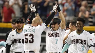 Corbin Carroll (7) es felicitado por Christian Walker luego de empujar dos carreras en la novena entrada del duelo del jueves 1 de junio de 2023, ante los Rockies de Colorado (AP Foto/Darryl Webb)