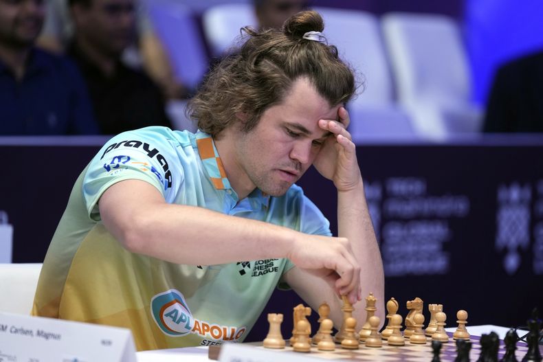 ARCHIVO - El noruego Magnus Carlsen, a la izquierda, de SG Alpine Warriors, juega contra el polaco Jan-Krzysztof Duda de Chingari Gulf Titans durante la Global Chess League en Dubái, Emiratos Árabes Unidos, del 1 de julio de 2023. (AP Foto/Kamran Jebreili, Archivo)
