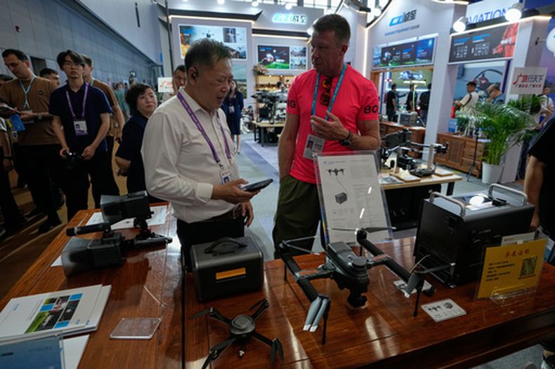 Un vendedor atiende a un visitante en un puesto que exhibe drones en la Feria de Cantón, en Guangzhou, sur de China, el 15 de abril de 2026. (Foto AP/Andy Wong)