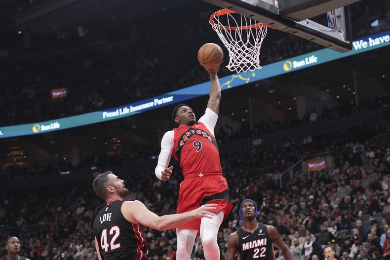 RJ Barrett de los Raptors de Toronto anota frente a Kevin Love del Heat de Miami en el encuentro de la NBA del domingo primero de diciembre del 2024. (Chris Young/The Canadian Press via AP)