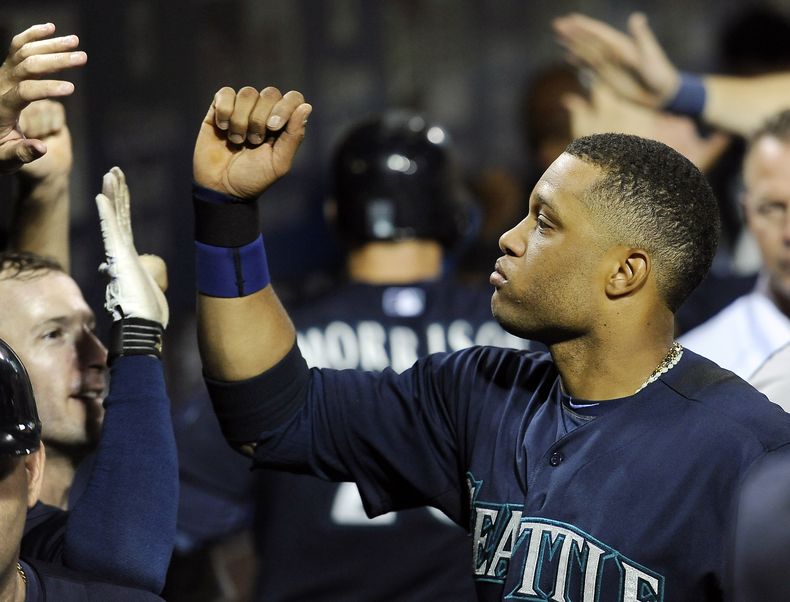 El jugador dominicano de los Marineros de Seattle, Robinson Can&oacute;, festeja en el dugout tras anotar una carrera contra los Filis de Filadelfia el martes, 19 de agosto de 2014, en Filadelfia. (AP Photo/Michael Perez)