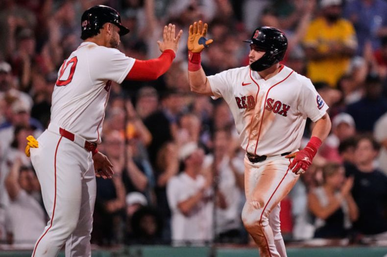 Caleb Durbin (derecha), de los Medias Rojas de Boston, es felicitado por Willson Contreras tras conectar un jonrón de dos carreras ante Cam Schlittler, de los Yankees de Nueva York, en la quinta entrada de un partido de béisbol, el jueves 25 de junio de 2026, en Boston. (Foto AP/Charles Krupa)