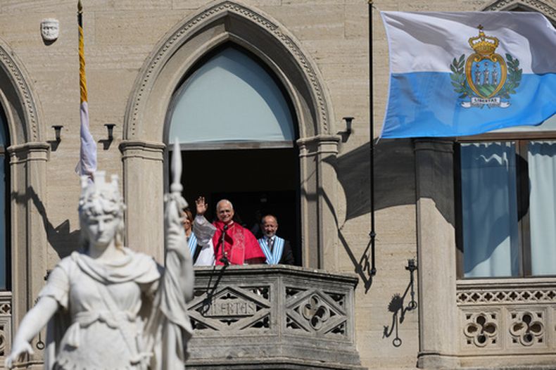 El papa León XIV (centro), flanqueado por los capitanes regentes Alice Mina (izquierda) y Vladimiro Selva, saluda a los fieles desde el balcón del Palazzo Pubblico durante su visita a San Marino, el 22 de agosto de 2026. (AP Foto/Andrew Medichini)