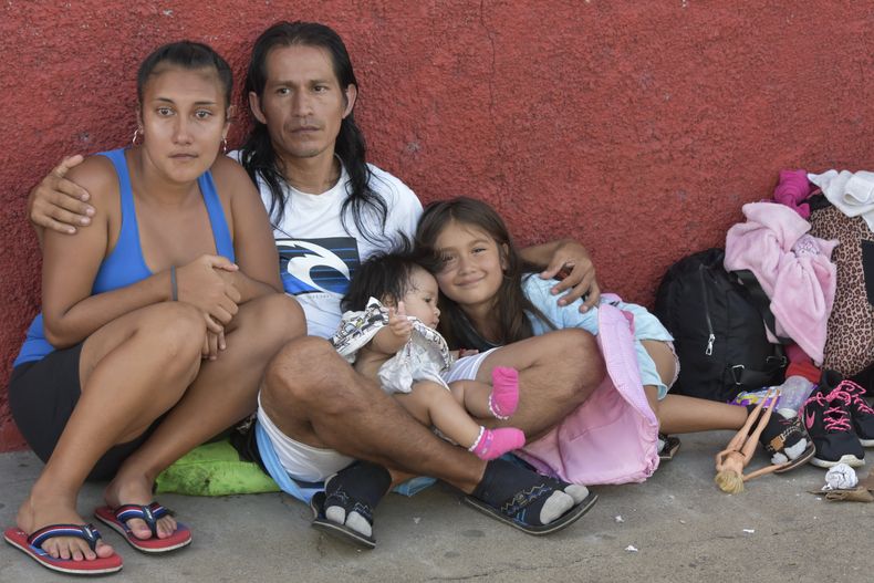 Rubén Rodríguez, en el centro, Gabriela Caballero, a la izquierda, y las hijas de ambos Alejandra Abigail, derecha, y Vivian, de Honduras, descansando después de llegar a pie con un grupo de migrantes a Huehuetán, México, el martes 31 de octubre de 2023, en su camino hacia la frontera de Estados Unidos. Los migrantes dicen que han solicitado permisos temporales de tránsito en Tapachula pero no los consiguieron, algunos después de esperar hasta dos meses, y continuaron su camino sin documentación porque no podían seguir pagando ni la comida ni el alojamiento. (AP Foto/Édgar Clemente)