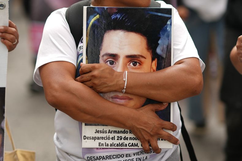 Un manifestante lleva una foto de un desaparecido mientras las familias se reúnen para pedir al gobierno que ayude a localizar a sus parientes desaparecidos, en el Día Internacional de las Víctimas de Desapariciones Forzosas, en Ciudad de México, el domingo 30 de agosto de 2026. (AP Foto/Eduardo Verdugo)
