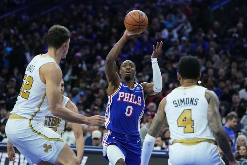 Tyrese Maxey, de los 76ers de Filadelfia, dispara ante Luka Garza y Anfernee Simons, de los Celtics de Boston, en el duelo del martes 11 de noviembre de 2025 (AP Foto/Matt Rourke)
