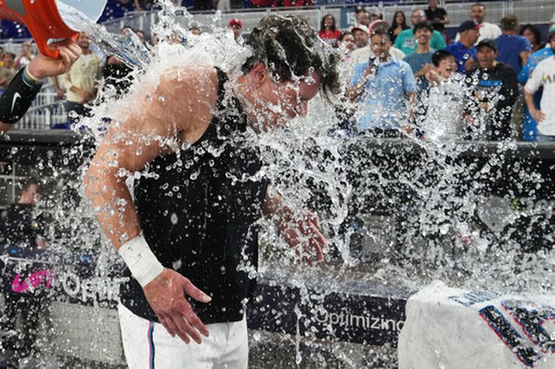 Griffin Conine de los Marlins de Miami recibe un baño tras la victoria ante los Filis de Filadelfia, el lunes 27 de julio de 2026, en Miami. (AP Foto/Lynne Sladky)