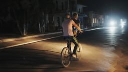 Un hombre pedalea en su bicicleta llevando a una niña durante el apagón programado de electricidad en Bauta, Cuba, el lunes 18 de marzo de 2024. La isla enfrenta una crisis de energía, con varios apagones en las últimas semanas. (AP Foto/Ramón Espinosa)