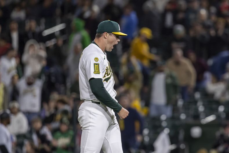 El lanzador de los Atléticos Mason Miller (19) reacciona mientras se aleja del montículo después de un juego de béisbol contra los Medias Blancas de Chicago, el viernes 25 de abril de 2025, en West Sacramento, California (AP Foto/Sara Nevis)