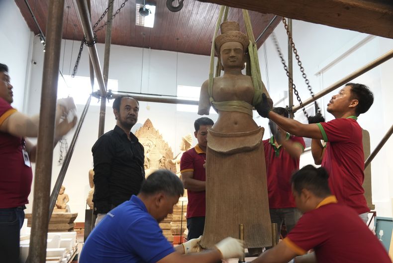 Personal especializado prepara una estatua que regresó de Estados Unidos a Camboya, antes de una ceremonia oficial en el Museo Nacional de Camboya, el jueves 4 de julio de 2024, en Nom Pen, Camboya. (AP Photo/Heng Sinith)