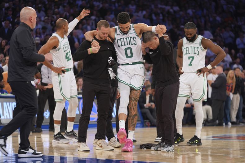 Los entrenadores ayudan a Jayson Tatum de los Celtics de Boston para salir de la cancha al lesionarse en el juego 4 de las semifinales de la Conferencia Este ante los Knicks de Nueva York el lunes 12 de mayo del 2025. (AP Foto/Frank Franklin II)