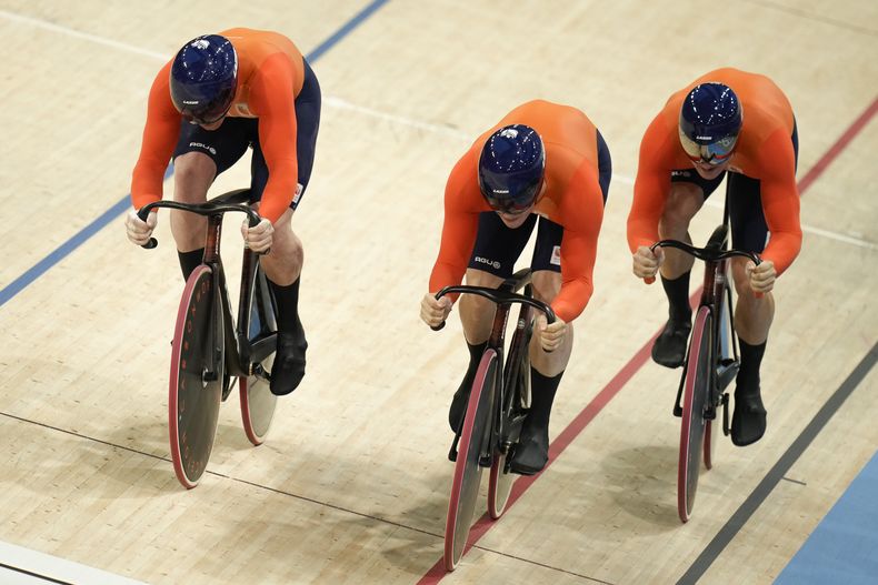 Los neerlandese Roy van den Berg, Harrie Lavreysen y Jeffrey Hoogland cruzan la meta al fijar un nuevo récord mundial durante el sprint por equipos del ciclismo de los Juegos Olímpicos de París, el martes 6 de agosto de 2024, en París. (AP Foto/Ricardo Mazalán)