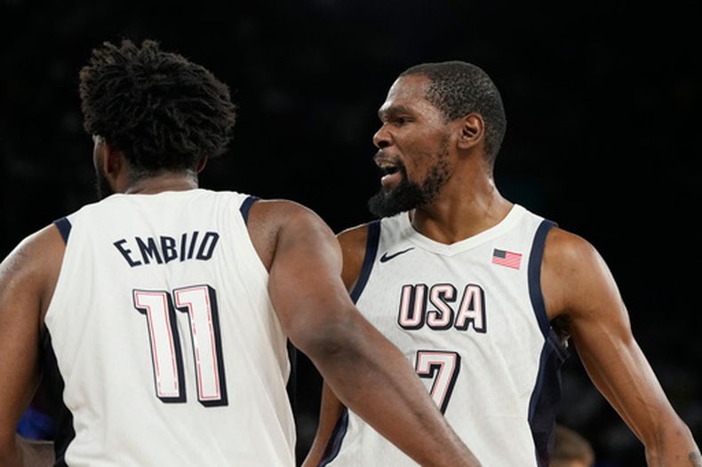 Joel Embiid y LeBron James, de la selección de Estados Unidos, reaccionan tras una falta marcada en las semifinales olímpicas ante Serbia, el jueves 8 de agosto de 2024, en París (AP Foto/Michael Conroy)
