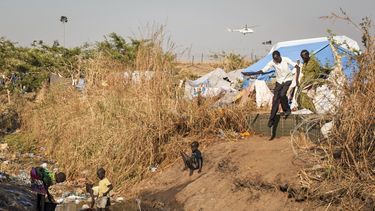 americateve | Ni&ntilde;os lavan sus ropas en un arroyo de aguas f&eacute;tidas que atraviesa un campamento para desplazados por la violencia en Juga, capital de Sud&aacute;n del Sur, el s&aacute;bado 11 de enero de 2014. Al fondo un helic&oacute;ptero de Naciones Unid