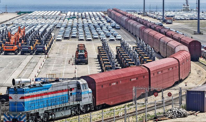 Maquinaria pesada y vehículos listos para ser transportados en tren, el 20 de junio de 2026, en Yantai, en la provincia de Shandong, China. (Chinatopix via AP)