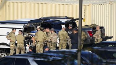Agentes se reúnen en el estacionamiento de una escuela en la búsqueda de Robert Card, un reservista del ejército al que las autoridades acusan de matar a tiros a 18 personas, el viernes 27 de octubre de 2023, en Lewiston, Maine. (AP Foto/Matt Rourke)