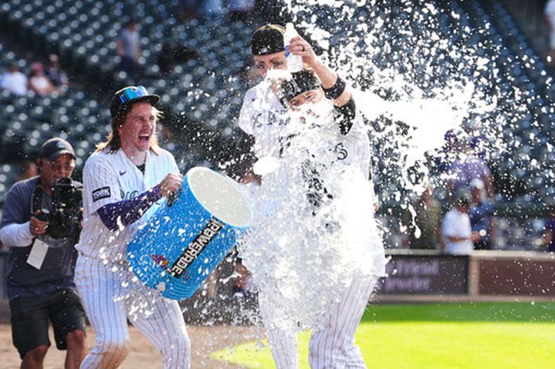 Jake McCarthy, de los Rockies de Colorado, arroja agua a Brett Sullivan, quien conectó un hit decisivo en el undécimo inning del juego ante los Orioles de Baltimore, el miércoles 2 de septiembre de 2026 (AP Foto/David Zalubowski)