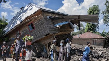 La gente camina junto a una casa destruida por las inundaciones en la aldea de Nyamukubi, provincia de Kivu del Sur, en la República Democrática del Congo, el sábado 6 de mayo de 2023. (Foto AP/Moisés Sawasawa)