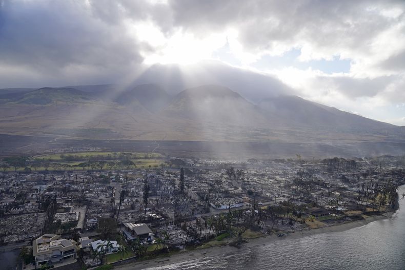 ARCHIVO - La luz del sol pasa a través de las nubes el jueves 10 de agosto de 2023, encima de viviendas quemadas por incendios en Lahaina, Hawai. (AP Foto/Rick Bowmer, archivo)
