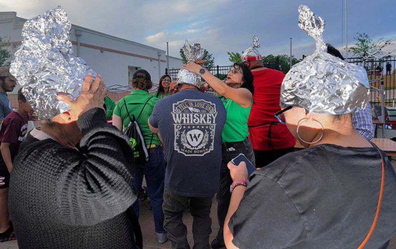 ARCHIVO - Asistentes juegan con sombreros de papel de plata en el Edinburg UFO Festival, el 5 de abril de 2024 en Edinburg, Texas. (Joel Martinez/The Monitor via AP, Archivo)