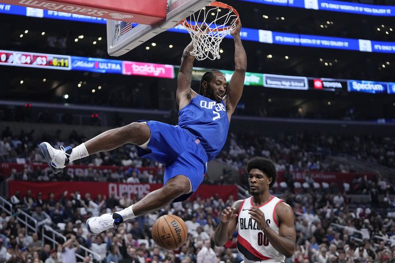 Kawhi Leonard realiza una clavada por los Clippers de Los Ángeles, frente a Scoot Henderson, de los Trail Blazers de Portland, el miércoles 25 de octubre de 2023 (AP Foto/Mark J. Terrill)