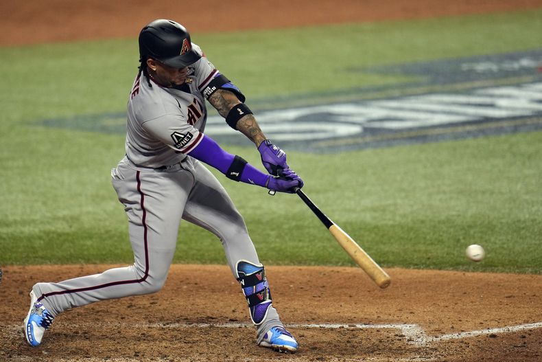 El dominicano Ketel Marte, de los Diamondbacks de Arizona, batea un sencillo de dos carreras ante los Rangers de Texas, el sábado 28 de octubre de 2023, en Arlington (AP Foto/Julio Cortez)
